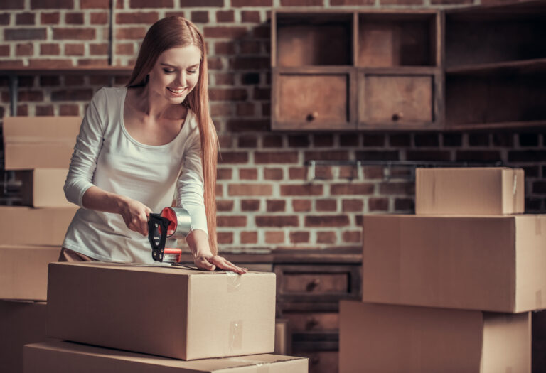 A woman is opening a box during a relocation with a screwdriver.