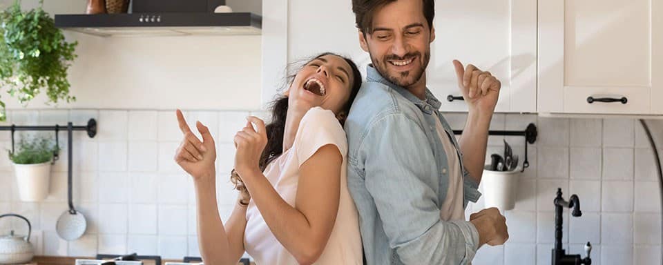 a man and a woman standing in a kitchen.
